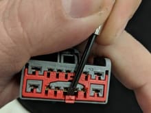 Insert a small screwdriver, then slide red retainer forward
