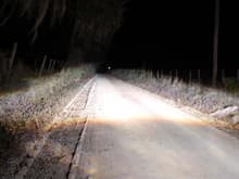 High beams again, this time looking down a dirt road.