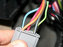 Step 7: Locate the connector on the back (towards the a pillar) of the fuse box with the orange, red, green, blue, and black connectors. Disconnect this connector and locate the BLUE/BLACK 12 gauge wire.