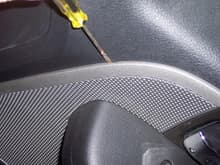 place small flat screwdriver in slot and pry to pop out speaker grill