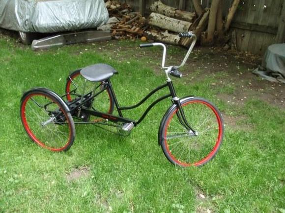 early-80s Huffy Villager trike
flat black with red wheels
renamed "Unholy Driver"
comfy...and it has a Posi rear! :)

since this picture: got the rear basket painted black and put it back on, got the shifter and front hand brake working, converted the front fork to a (slightly more) modern 26" mountain bike fork/wheel/tire, and the rear wheels are being re-spoked to mount a (slightly more) modern 24" mountain bike rim/tire