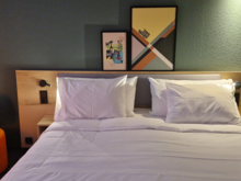 Apparently, something has been done about that—there were now two larger, thicker pillows, much better. There was a broken lamp above the bed, though. And the dimmer on the floor lamp no longer had an “off” setting—you had to unplug it from the socket.