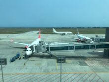 The airport uses aerobridges,
In the far distance you can see the ocean,
It is paralel to the runway