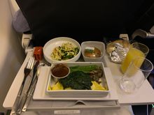 CDG-IST: cold pasta salad appetizer; main of pulled chicken wrapped in pasta with spinach, mushrooms and snap peas; small cupcake dessert. All on china and with real silverware