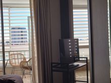 Tv on TV cabinet with wheels and balcony with chairs. 