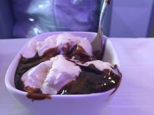 Two huge scoops of vanilla ice cream with chocolate sauce.