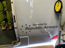 The Republic Airways logo is painted on the fuselage just to the right of the front door 