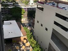 View of pool from our west-facing balcony. Kuhio Avenue seen behind it.  Parking structure to the right is part of International Market Place.