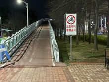 There’s a sign that says “no motorbikes”. I think this is a bike lane. OP recommended walking up the slope (which I did), but it seems like you can get by walking below too. 