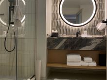 Bathroom with walk-in shower. It’s a small room with a single vanity and no door separating the toilet.
