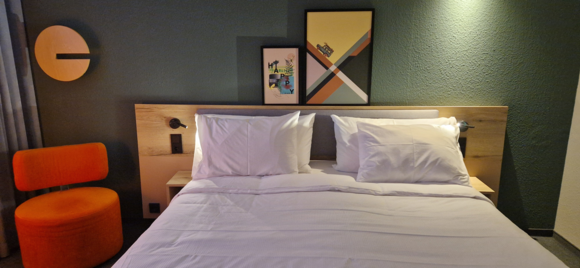 Apparently, something has been done about that—there were now two larger, thicker pillows, much better. There was a broken lamp above the bed, though. And the dimmer on the floor lamp no longer had an “off” setting—you had to unplug it from the socket.