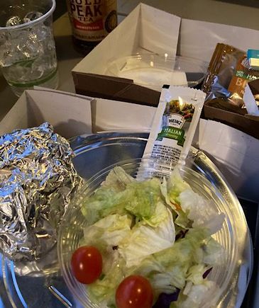 Foil-wrapped roll, salad, an iced tea, and a blonde brownie. 