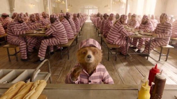 Image from Paddington 2 - scene with prisons in pink tint clothes