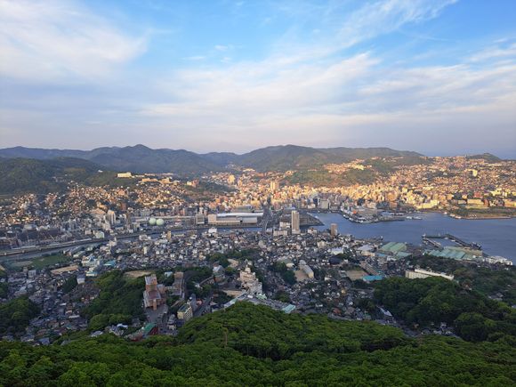View of Nagasaki  from top of Mt Insayama  on a beautiful evening  ( 30 mins before sunset)  peace park out of sight to left. Glover hill to right   Hilton  Hotel and  JR station in centre ( wind was cold that night ). Beautiful after sunset with all the lights on in the city