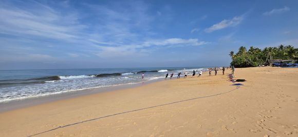 View of the beach outside the hotel in the morning, including fishermen