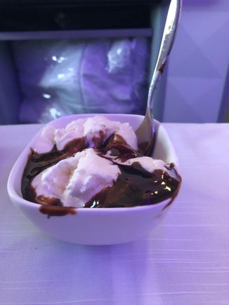 Two huge scoops of vanilla ice cream with chocolate sauce.