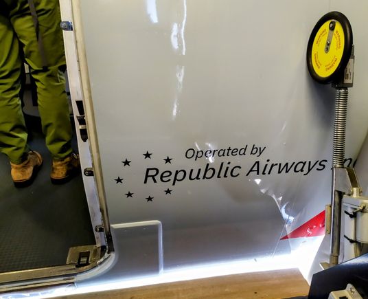 The Republic Airways logo is painted on the fuselage just to the right of the front door 
