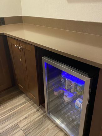 Mini fridge with sodas, water, yogurt, milk