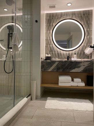Bathroom with walk-in shower. It’s a small room with a single vanity and no door separating the toilet.