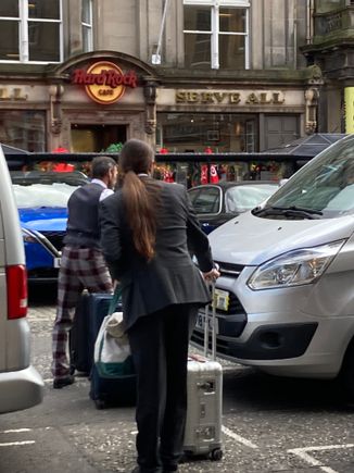 Two of the three doormen helping guests with their luggage for the taxi to the airport