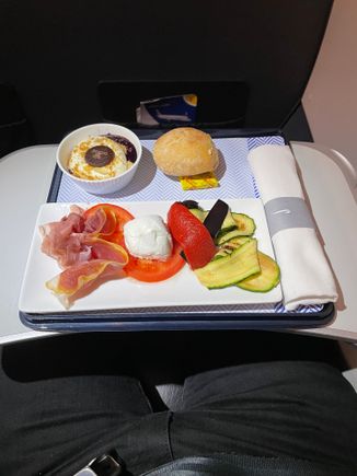 Prosciutto, mozzarella, tomato and roast vegetables, bread roll and a blueberry cheesecake dessert (?)