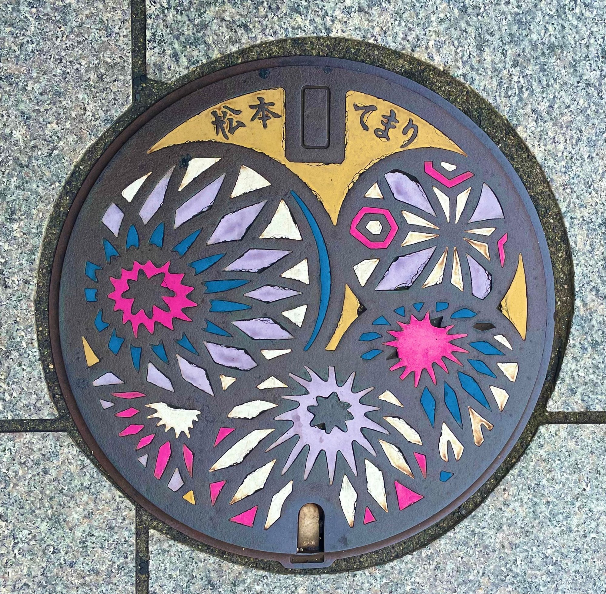 Matsumoto manhole cover design. It is a pattern based on a traditional Japanese folk craft of a decorative ball called 