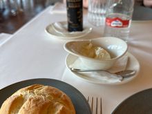 Bread with the ailioli in the dish in center, and the oil in the background.