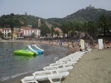 Walking past the beach, windmill and Fort St Elme visible in distance