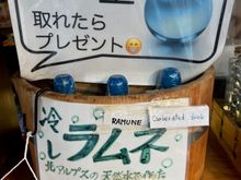 Bottles of Ramune in the bucket. You can just see the blue marble top peeking over the edge.