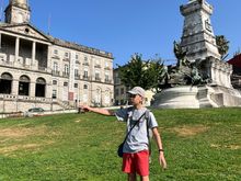 My son imitating Henry the navigator; Palácio do Bolsa in the background 