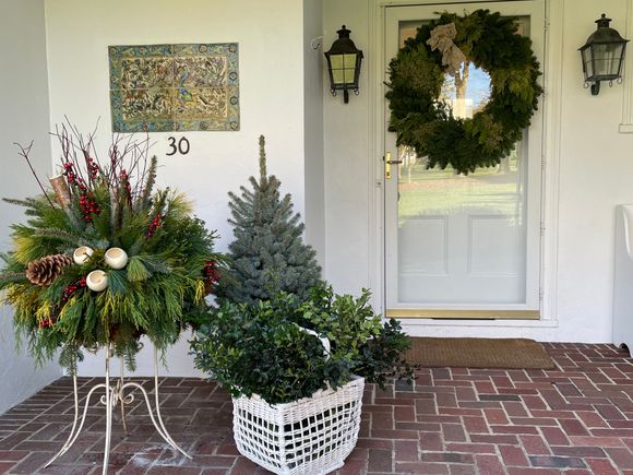 We still need to add some berries to the basket of holly. I think this and my glass tree collection will give us spirit. We also put candles in our windows. I’ll update with an evening photo. 