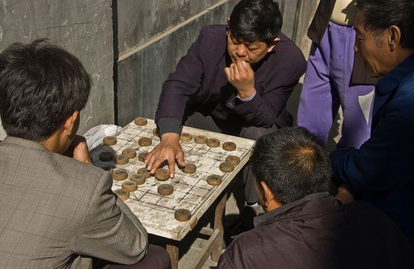 In Ju'er hutong, one may see autumnal mahjong gatherings outside of the 'siheyuan' courtyard walls.