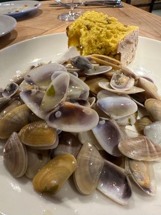 Another photo of the heaping plate of clams; this is a racion, priced at 25 euro, offered with one of two varieties of crusty, perfect bread.  This chunk bears the yellow hue of turmeric.