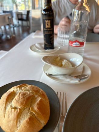 Bread with the ailioli in the dish in center, and the oil in the background.