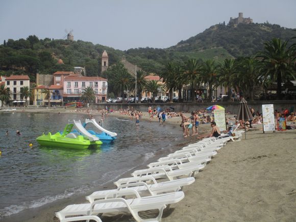Walking past the beach, windmill and Fort St Elme visible in distance