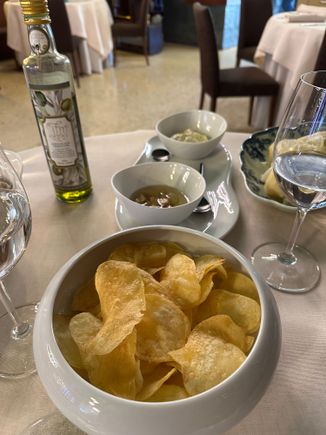 Galician potato chips, fried in olive oil, are famous throughout Spain, and on my trips home, I often see travelers toting the large round metal tins filled with them on the plane. Much better than the usual ones we have in the US, these are also less salty.  Look at then prices in NYC and you can see why people bring these home with them:   

https://despanabrandfoods.com/collections/bonilla-a-la-vista?srsltid=AfmBOoq3fTYa-17KCxdDSXo5LJ9O9av12BdEAB4aBQZ_u56MMoAqN2WE