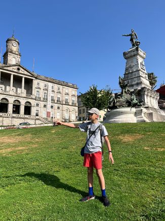 My son imitating Henry the navigator; Palácio do Bolsa in the background 