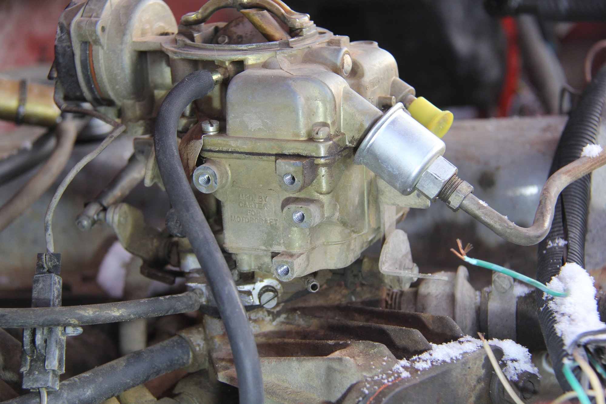 This  is  the  right  side  of  the  carb.  after  I  removed  a  couple  of  things  that   were`nt  doing  anything..  I  also  found  the  tag  on  the  carb. , you  could  not  make  out  the  numbers  so  I  brought  it  in  and  cleaned  it  up..  I  used  the  misses  toothbrush , but  I  don`t  think  we  need to  tell her  that !!!   I noticed  the  vacuum port near the  base  of  the  carb.  There was  no hooked  up  to  this in fact  you could  not  even see  this  port..
