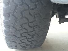 Passenger front tire showing cupping on inside of tire.