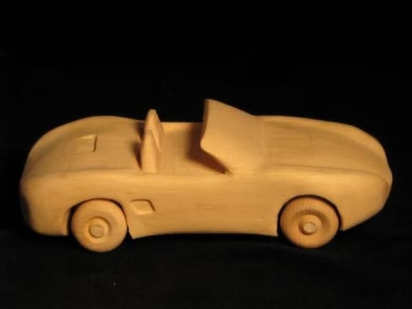 Soon, I'll be a grandfather, and thought  my grandchild shouldn't have to wait as long as I did to get my first Porsche. So, I carved this Boxster for him/her. Carved from a single piece of wood except for wheels/axles.