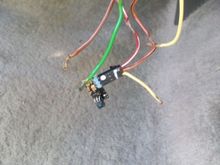 This was how I found the wires to the security feature. Not sure what he was trying to accomplish. 
The green and brown wires are to the key sensor (I believe,)
The bared wires have been repaired, and the resistor has been soldered into the yellow (cut) wire, and the (bared) orange/black wire.