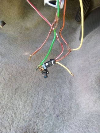 This was how I found the wires to the security feature. Not sure what he was trying to accomplish. 
The green and brown wires are to the key sensor (I believe,)
The bared wires have been repaired, and the resistor has been soldered into the yellow (cut) wire, and the (bared) orange/black wire.