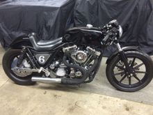 87' FXR frame with a decked out stroker, hand made rear fender and seat, aluminum gas tank, progressive 412 shocks, late model narrowglide front end powdercoated, stock HD wheels powdercoated, GMA brakes w/ drilled and polished rotors,  RSD cafe fork mount bars w speedo mount and grips, custom made rear sets for braking and shifting, Ness side covers and stash tray and 100% LED lighting.