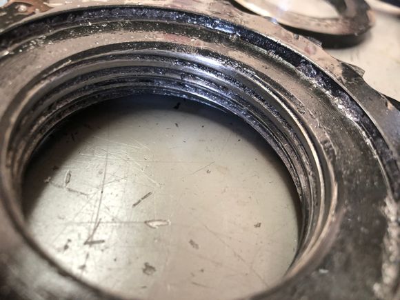 The threads are ground down. Probably the metal shavings I saw in the fluid