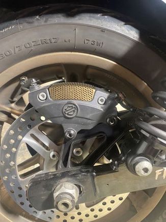 Figured out that the Vrod snap in screen fits all the rear Brembo's. It comes as plain Stainless Steel but I painted it to match my rims. Burnt Bronze. 
