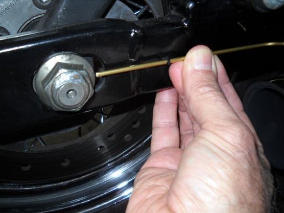 After I had got my alignment dead on with the method to center of the axle nuts, I then checked the distance on each side from alignment hole to outer circumference of the axle nuts. They are exactly the same dia on each side so you can just measure to the edge which is a straight shot and easeir than trying to maintain parallel measurements to the center of the nut which is out further on one side than the other.
