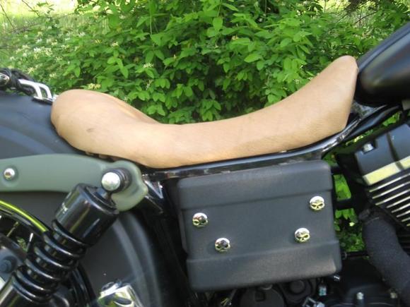 Stock Dyna seat after being trimed and wraped in brown Buffalo hide.