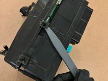 3 clips on left side. 1 more clip on rear not shown. 6 clips total hold bottom cover to fuse box body.
