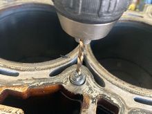 Start out a punch, then with a #2 drill bit (from the kit), then work up to a #3 drill bit.  Be careful not to drop (too much) metal in the cooling passages.  