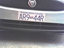 Held on by very good quality two way construction tape able to handle the elements. As I had changed plates on one of the other cars with a bit of patience and a low setting on heat gun removal was possible with no issues to the paint